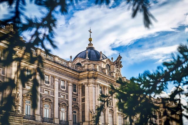Un edificio con cúpula del Madrid histórico, entre las ramas de los árboles